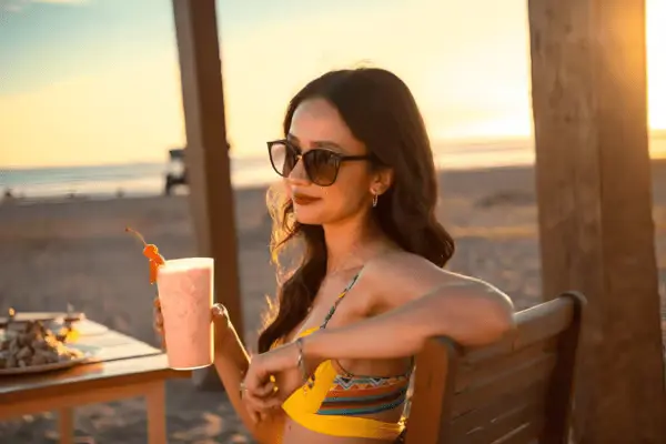 Relajación en la playa al atardecer Disfrutando una bebida tropical en la playa al atardecer.